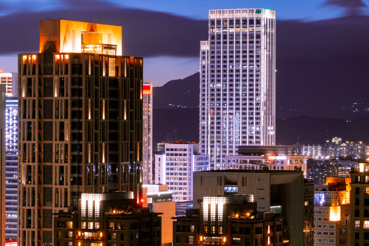 Vibrant cityscape of Taipei's illuminated skyscrapers against a night sky.