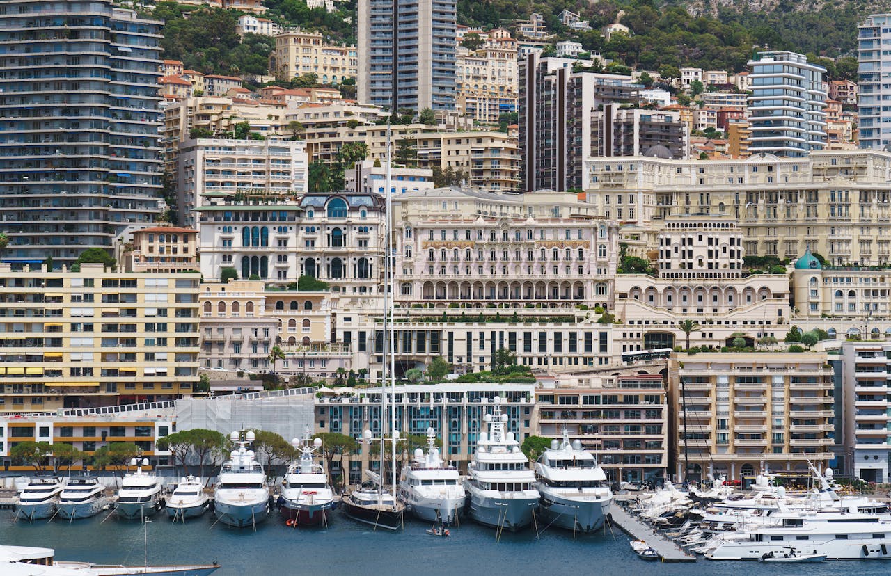 Luxurious yachts moored along Monaco's stunning marina with city skyline.